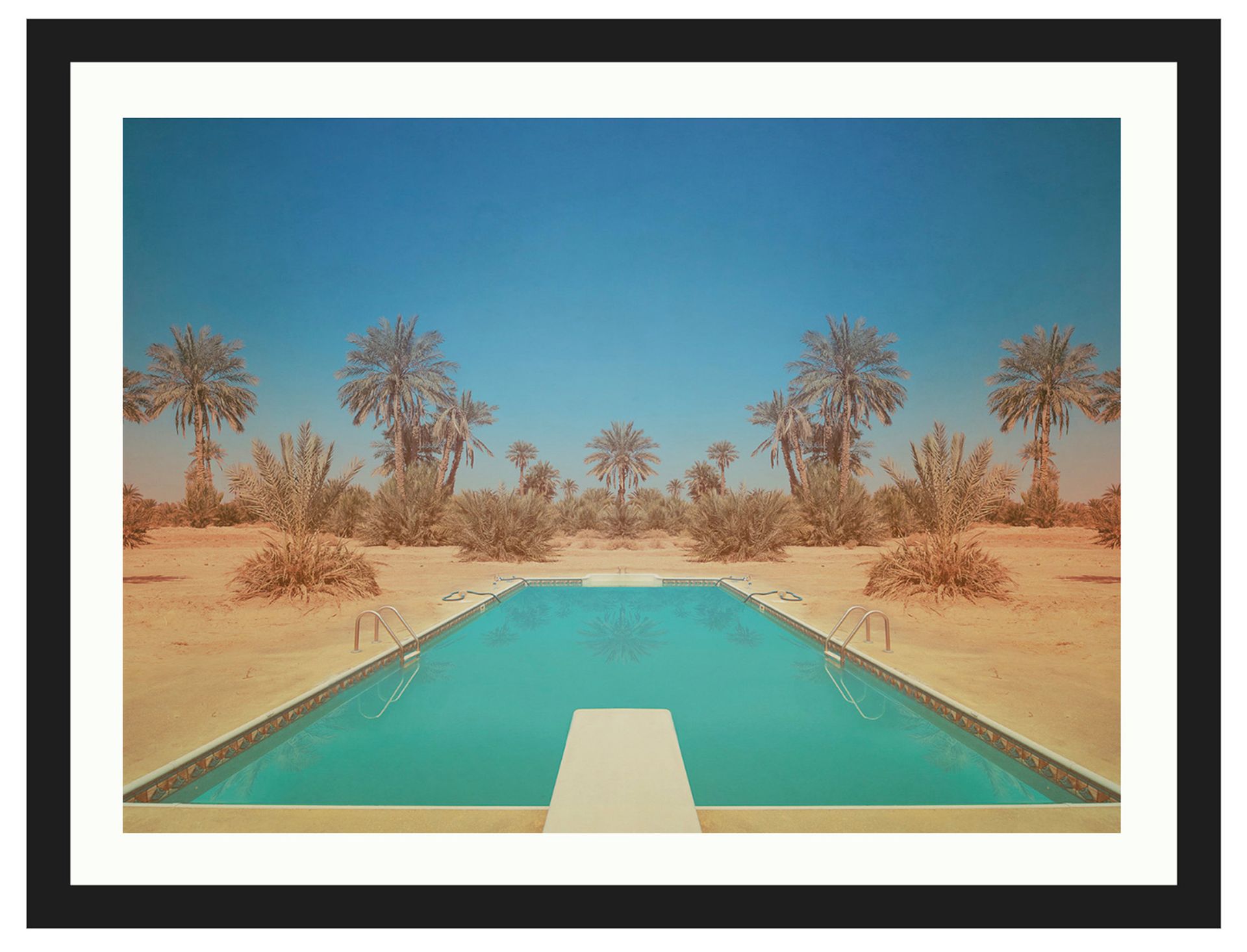 Turquoise pool in a sandy desert with palm trees under a clear blue sky