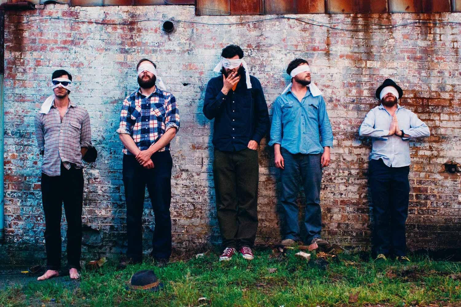 Dr. Dog poses in firing squad for Asheville music photo outside the Grey Eagle Music Hall, portrait by North Carolina music photographer Sandlin Gaither 