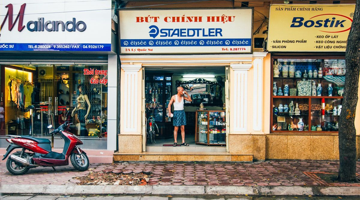 Vietnamese man drinking coffee in storefront door, old French Quarter, hanoi, small group travel and food photography tours with Sandlin Gaither Explorer's Club