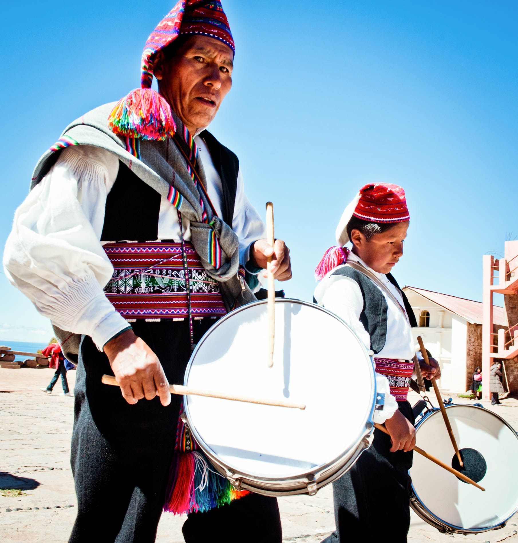 man and boy drumming during wedding procession, Isla Taquile, Lake Titicaca, Peru, small group travel and food photography tours with Sandlin Gaither Explorer's Club