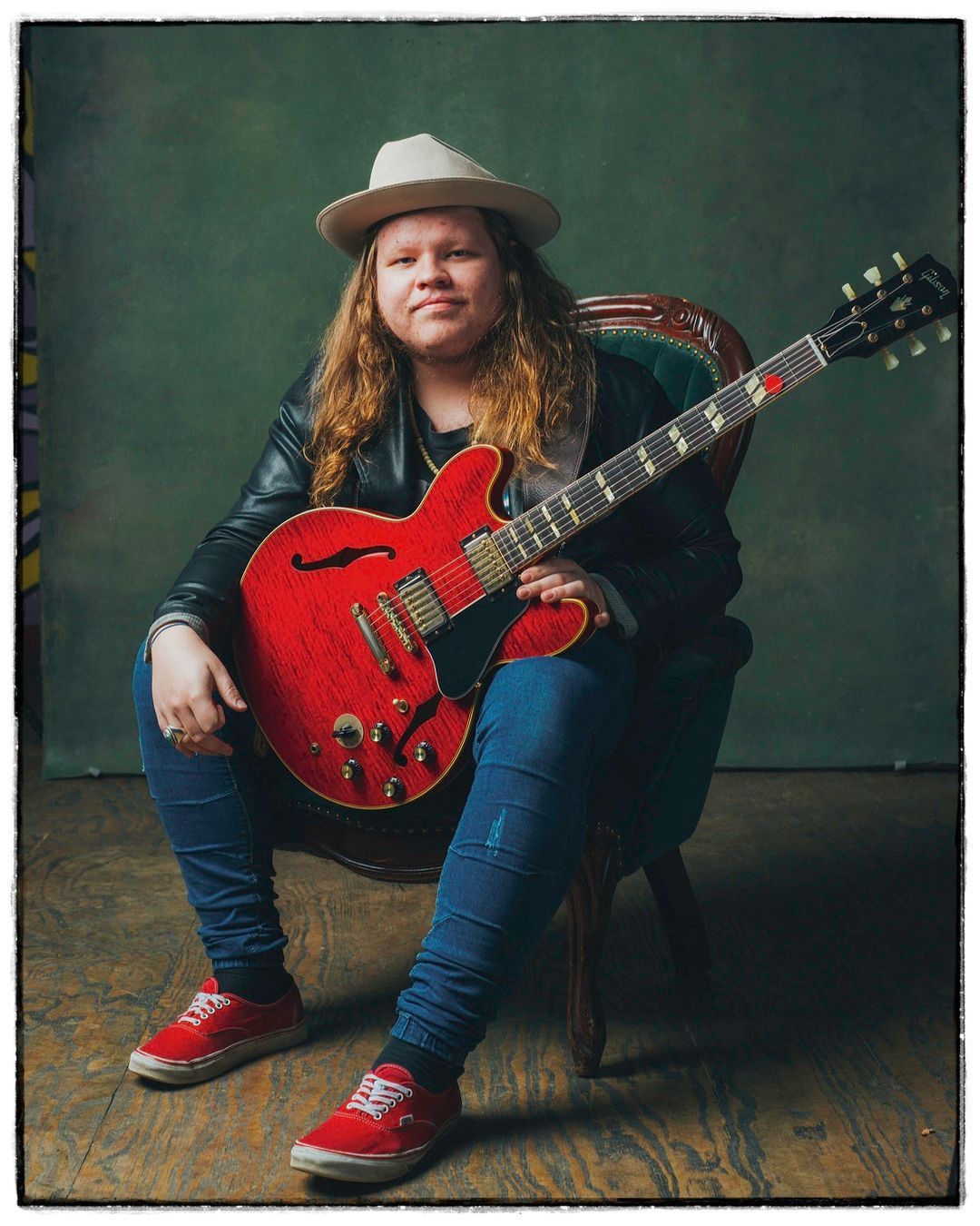 marcus king blues musician poses with red gibson guitar in Asheville, NC for portrait by music photographer Sandlin Gaither 
