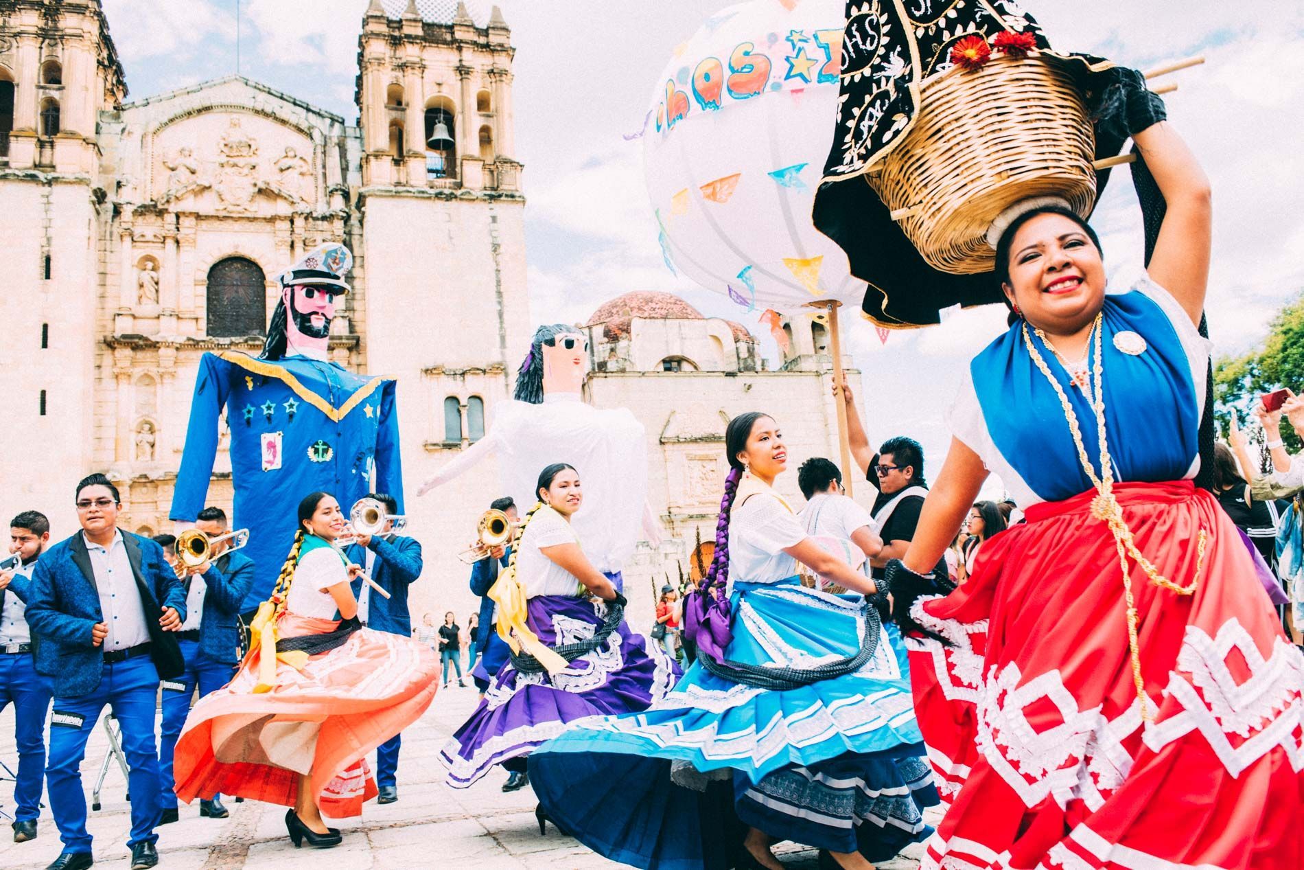 colorful women dancing in traditional dress during Guelaguetza festival, Oaxaca, Mexico, small group travel and food photography tours with Sandlin Gaither Explorer's Club