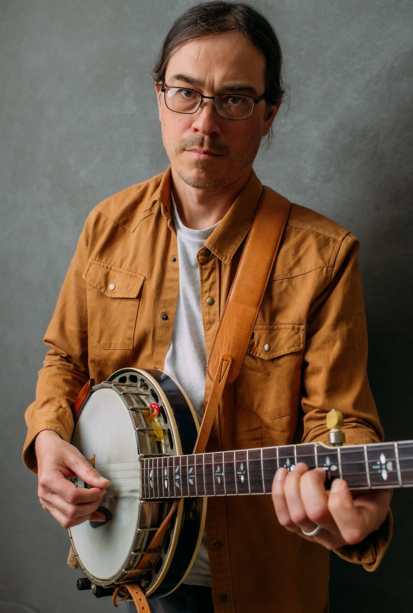banjo player Jesse Langlais with instrument, photographed in studio by Asheville music photographer Sandlin Gaither 