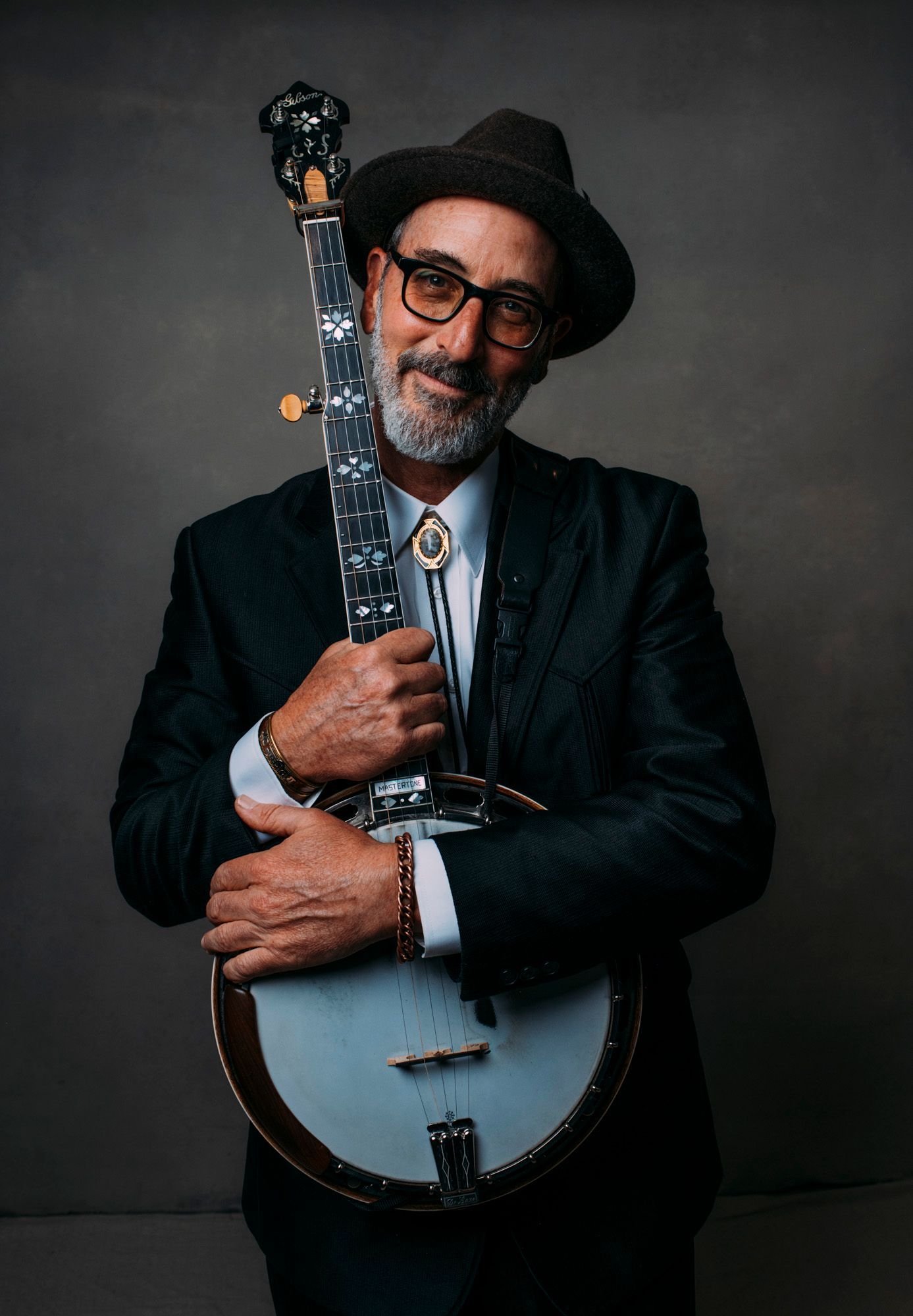 rudy bluegrass musician poses with banjo in Asheville, NC for portrait by photographer Sandlin Gaither 
