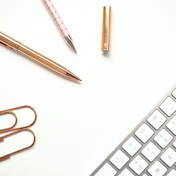 Kugelschreiber, eine Mac Tastatur und ein Bleistift