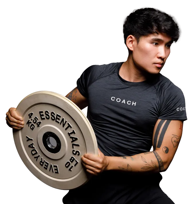 A person in a gray performance shirt holding a 10 lb, 4.5 kg weight plate in front of their chest.
