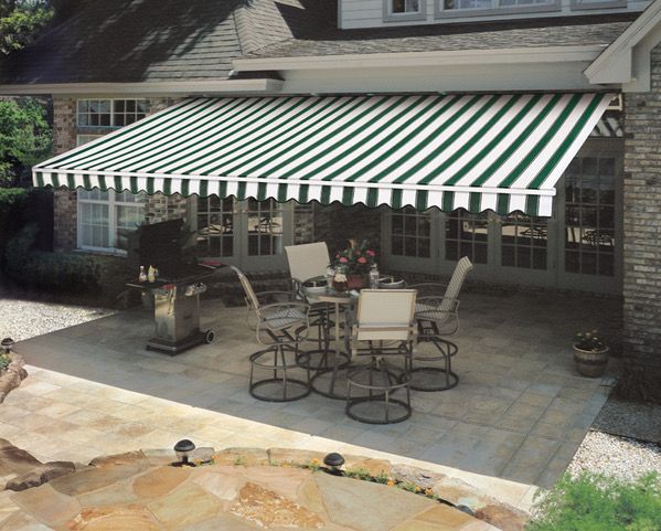 Patio with striped green and white awning, table and chairs, and a stone patio.