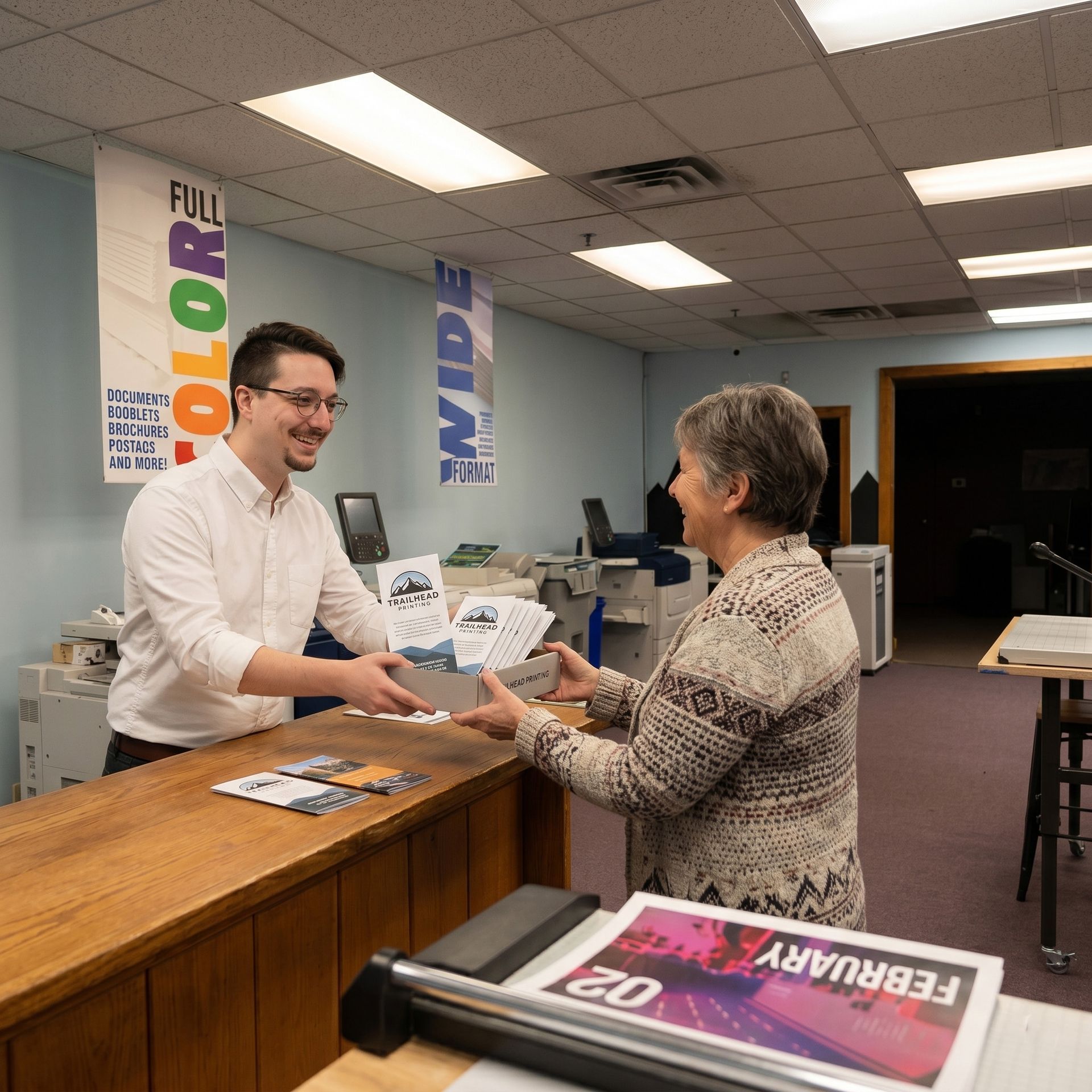 Man handing a brochure to a customer at a color printing shop counter