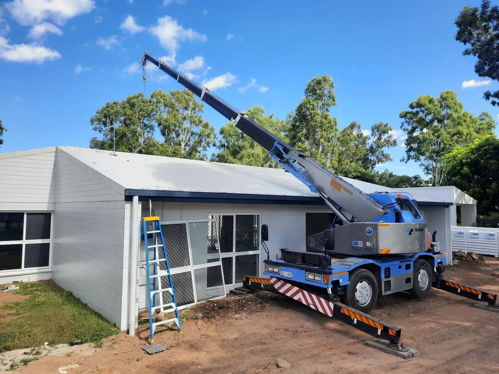 Crane Lifting Something Onto a Building Under Construction — Presto's Cranes & Rigging NQ in Garbutt, QLD