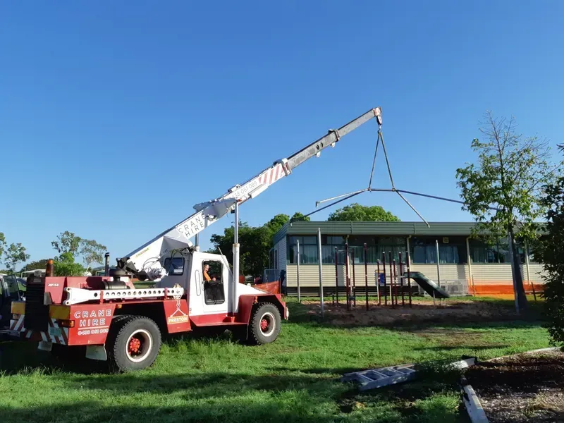 Crane Lifting a Structure at a School Playground on a Sunny Day — Presto's Cranes & Rigging NQ in Garbutt, QLD