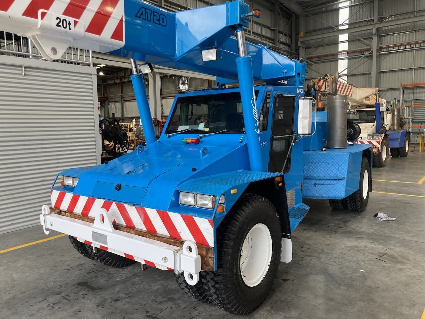Blue Crane Truck With Red and White Striped Bumper and Crane Arm — Presto's Cranes & Rigging NQ in Garbutt, QLD