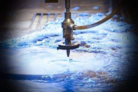 A Machine Is Cutting A Piece Of Metal With Water — JMG Maintenance & Fabrication In Muswellbrook NSW