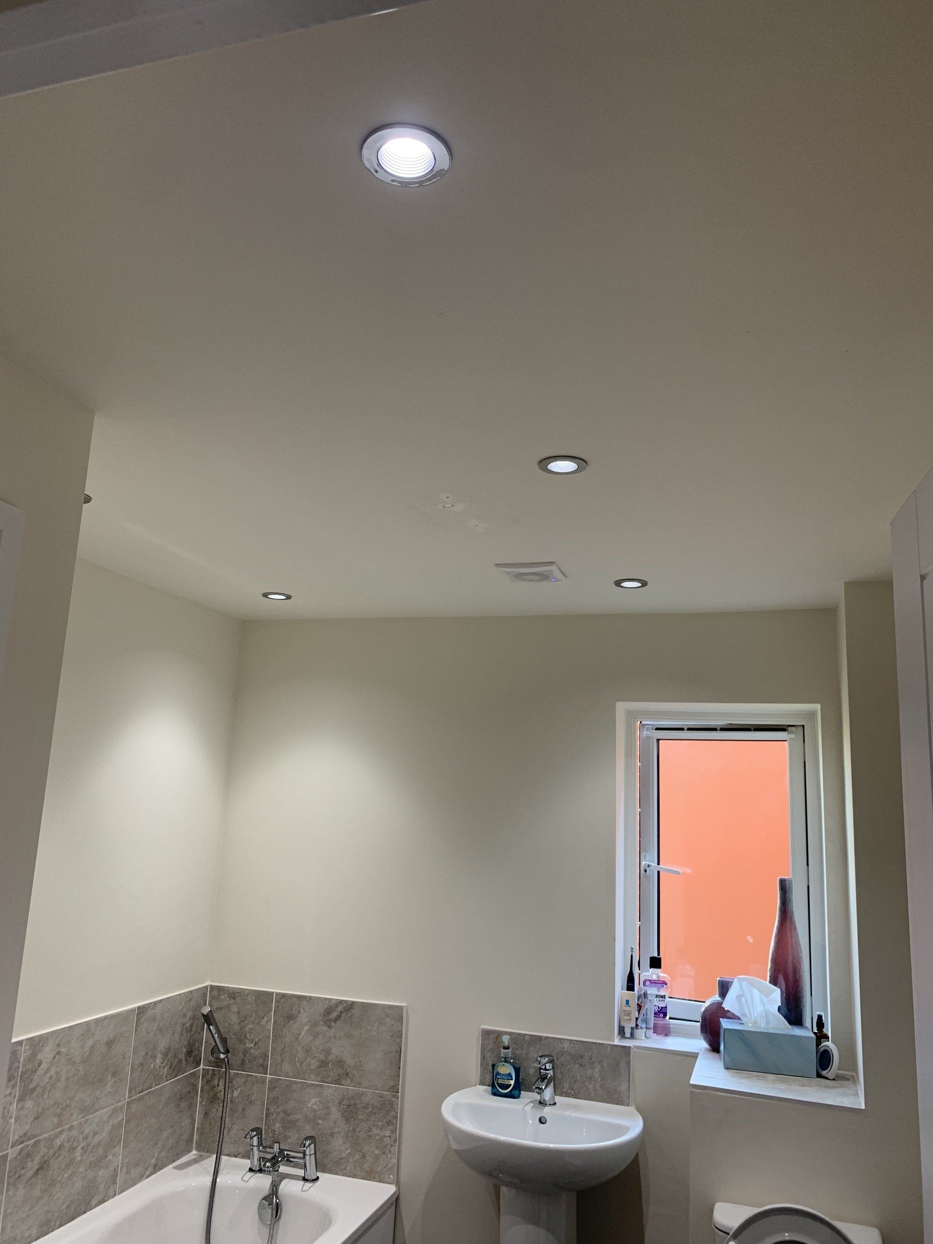 Electrician near me installing bathroom spot lights.  Electrician in Warrington