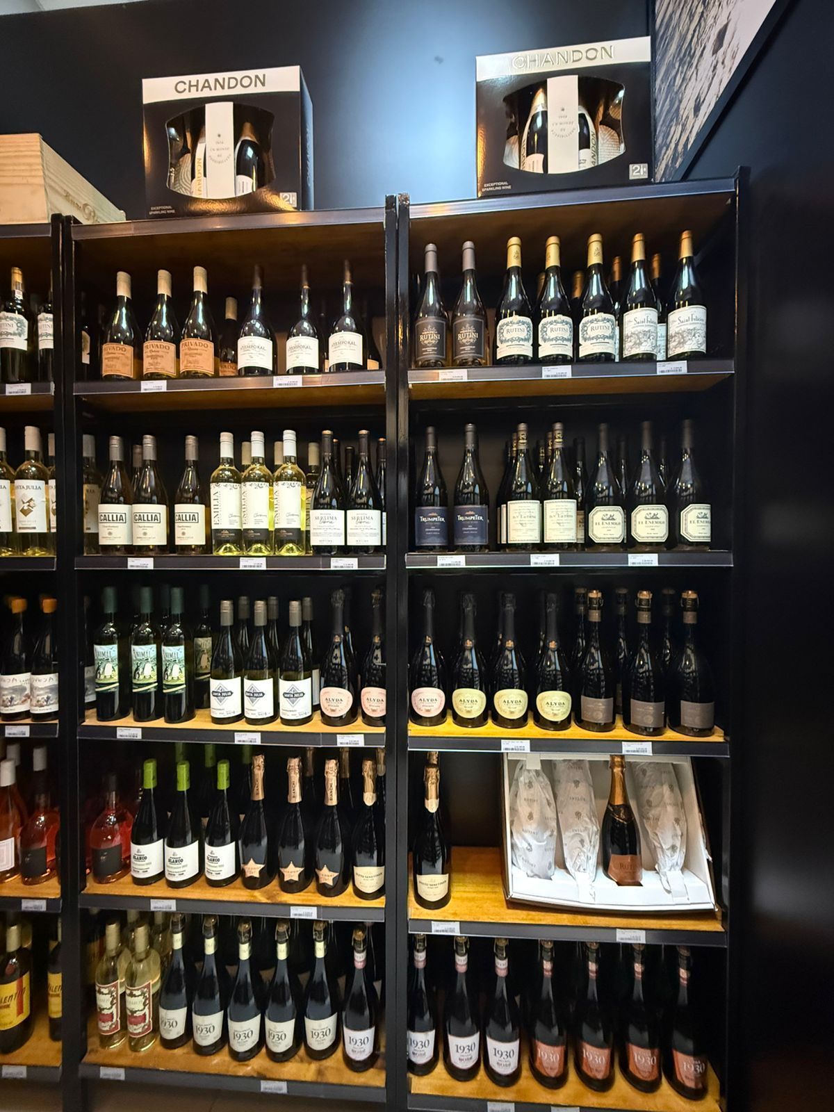 Botellas de vino exhibidas en estantes de madera en una tienda.