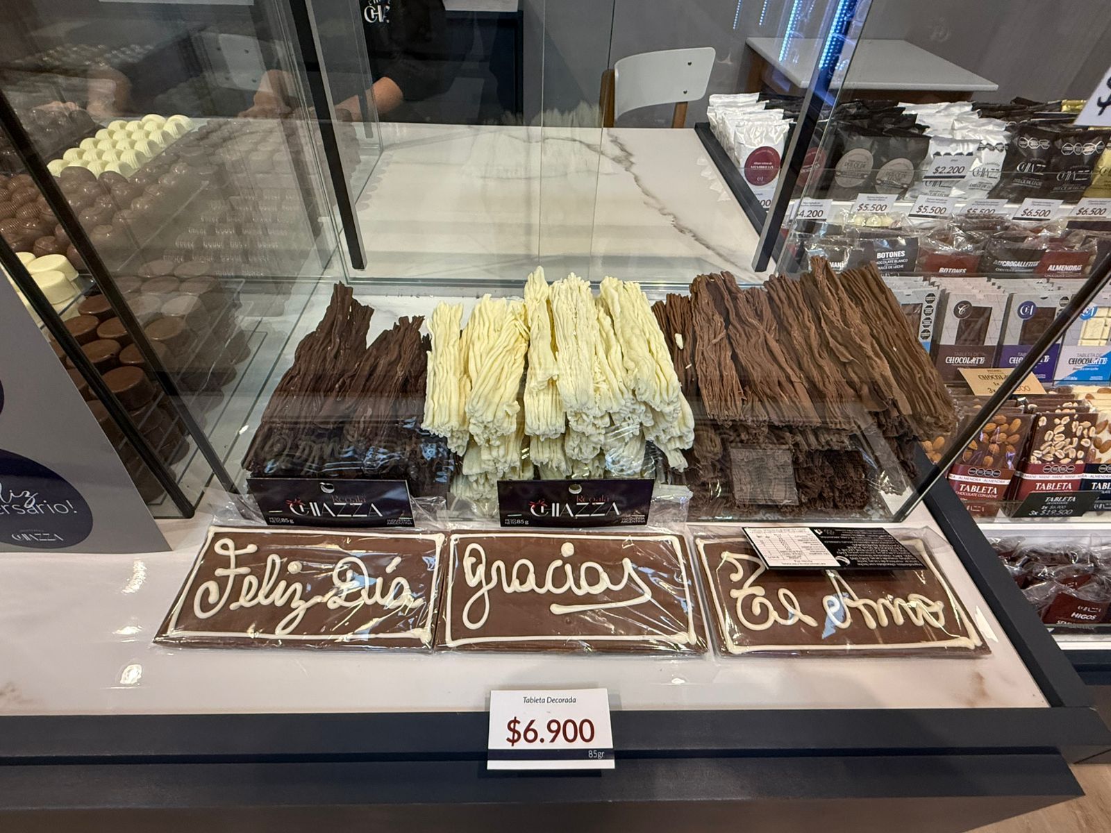 Vitrina expositora de chocolate con diversos palitos de chocolate bañados y placas de chocolate.