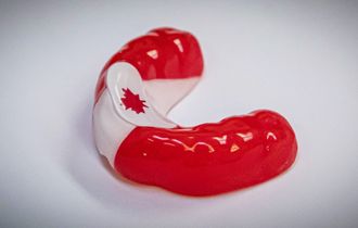 Red and white Canadian flag design on a custom mouthguard.