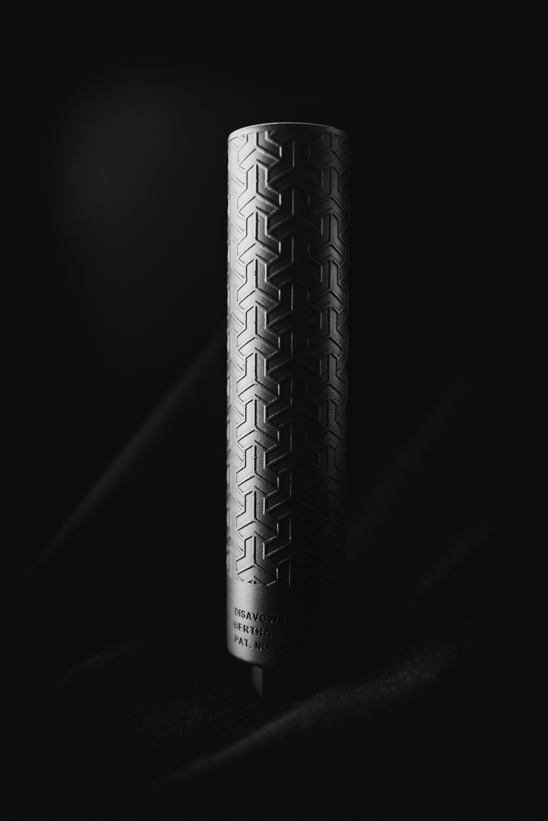 A black and white photo of a metal object with a pattern on it.