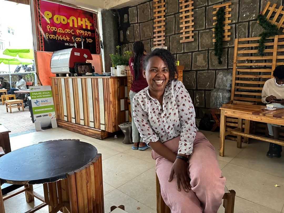 Woman sitting in a chair in her cafe 