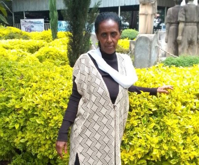 Ethiopian woman standing in front of her garden