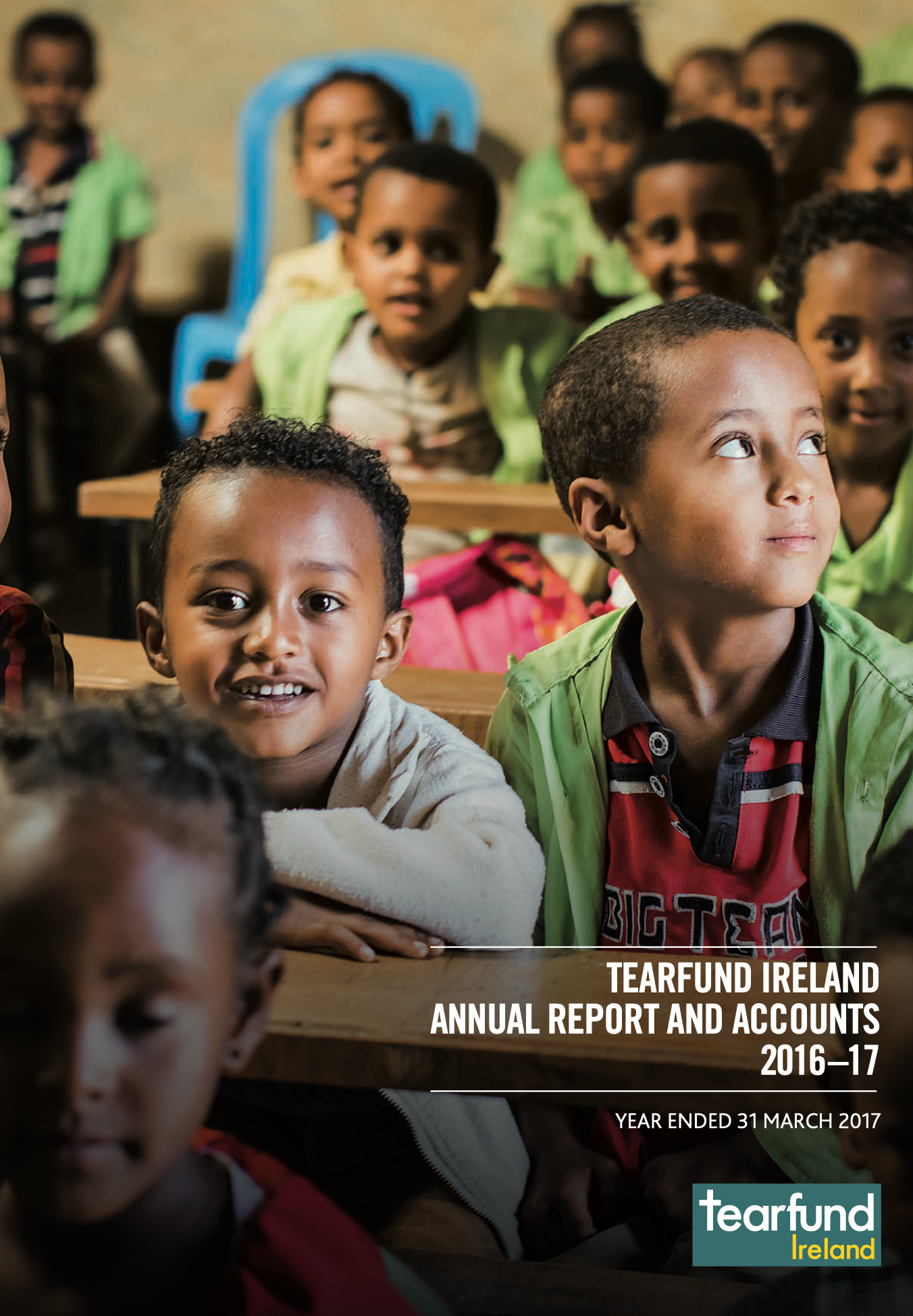 Children in a classroom, looking forward. Tearfund Ireland report cover.