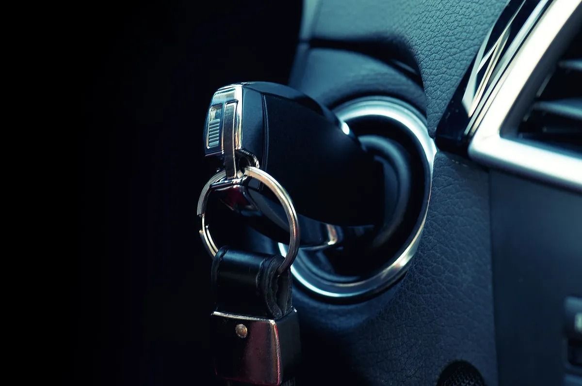 Car key in ignition with a key ring, close-up inside a car dashboard