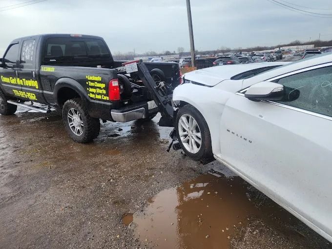 Black pickup truck rear-ended white sedan on a wet road, showing collision damage