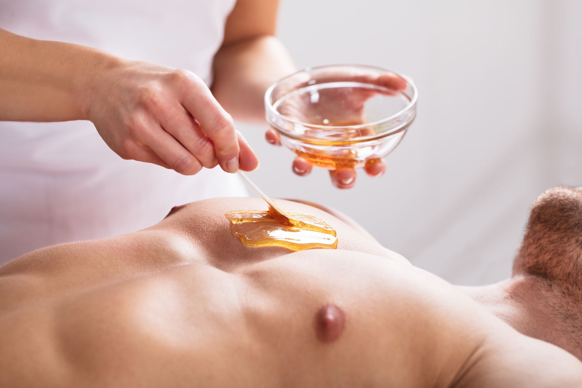 Image of a man getting his chest waxed