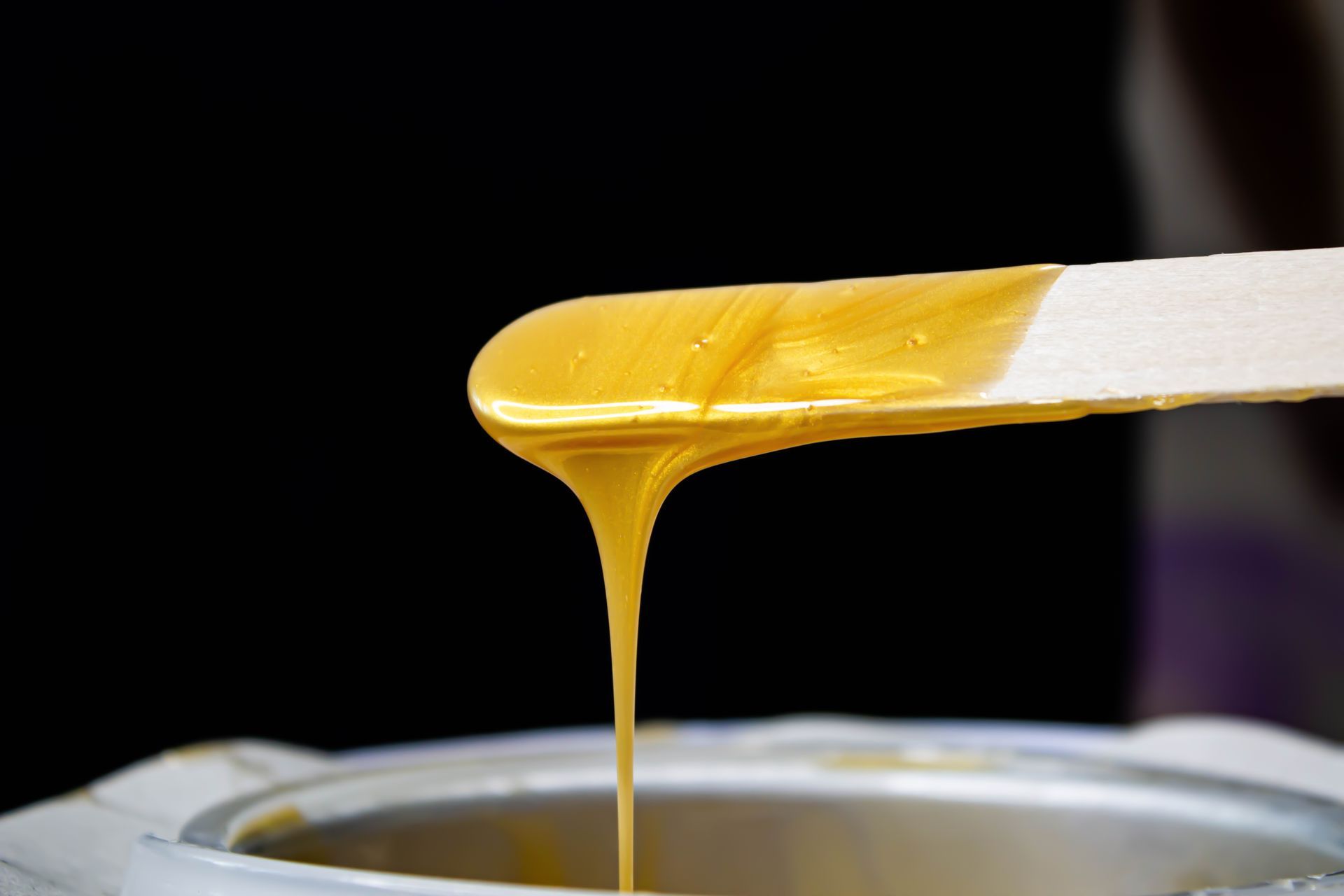 Image of hot wax dripping off an applicator