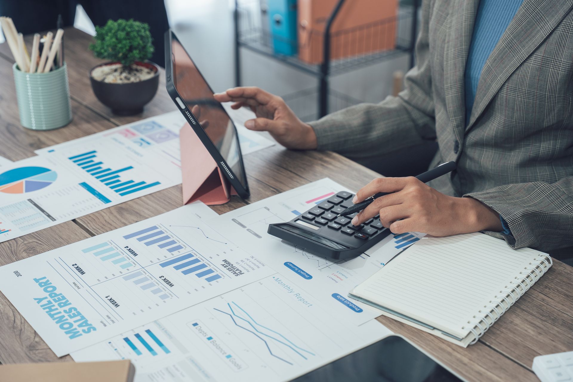 A bookkeeper performing bookkeeping services in the office, analyzing financial data.