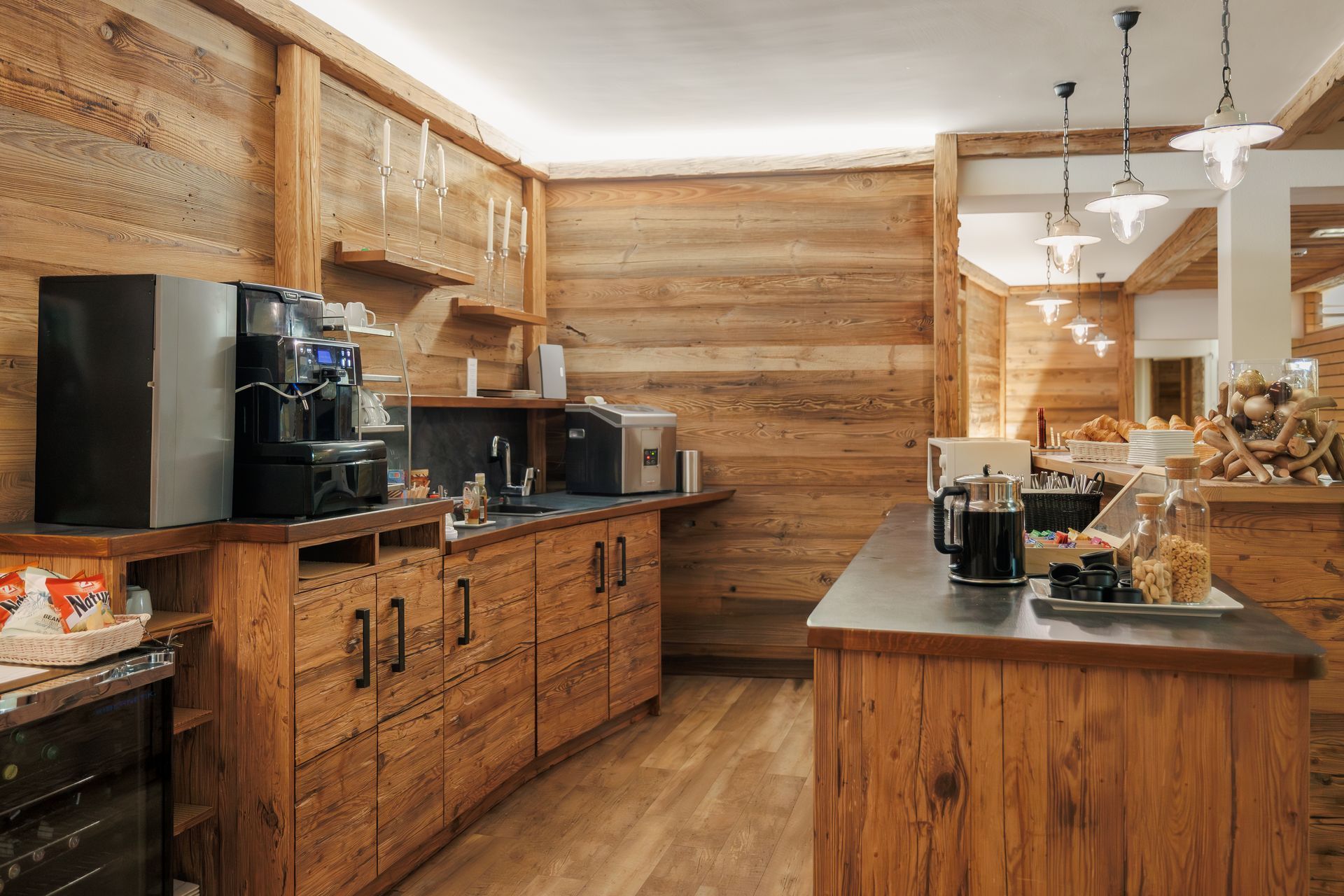 Rustic wood kitchen with island, black appliances, and pendant lights