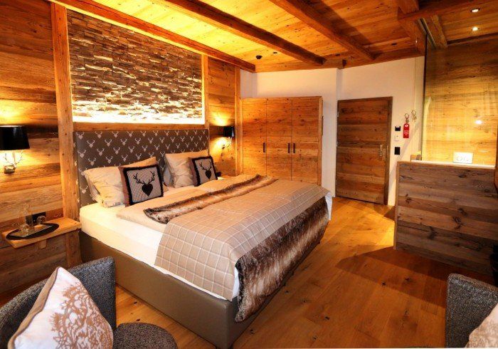 Cozy rustic bedroom with wood beams, warm lighting, and a neatly made bed