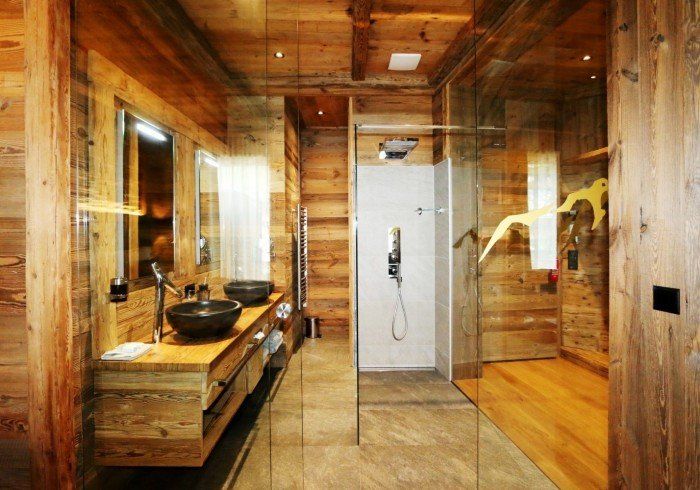 Wood-paneled spa bathroom with glass shower, double sink vanity, and tiled floor