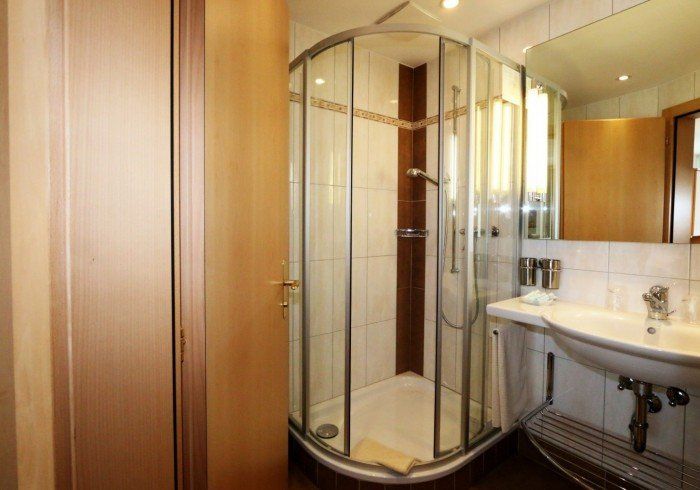 Modern bathroom with a corner glass shower and white sink vanity
