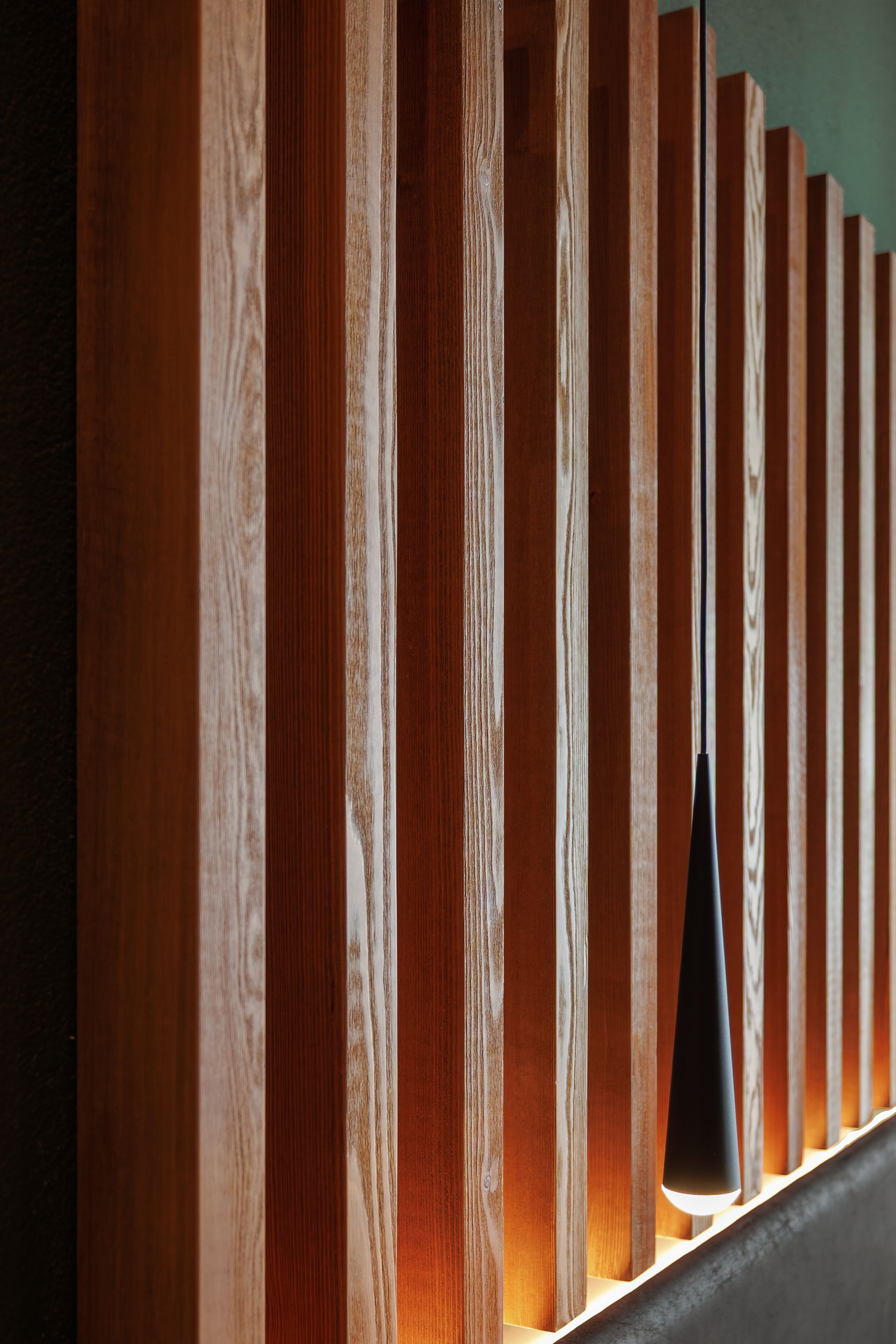 Wooden slats lit from below, forming a modern architectural partition