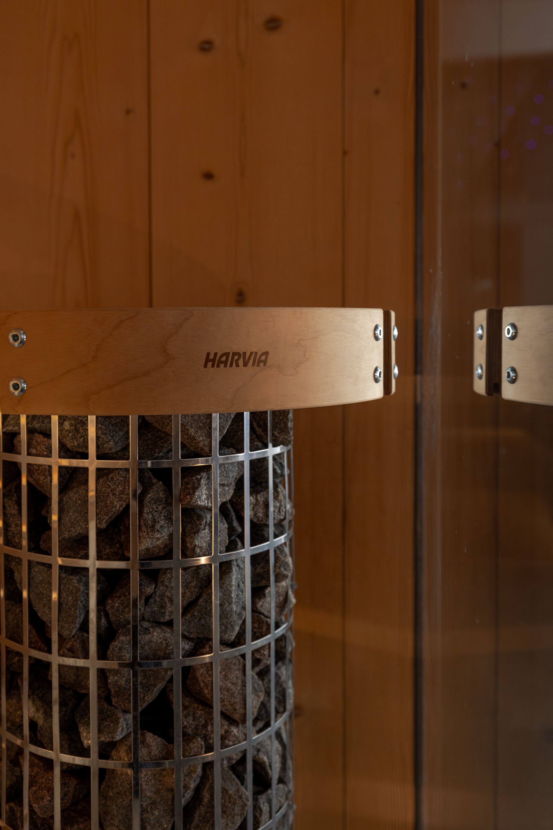 Wood-paneled wall with a glass-fronted wood storage cabinet filled with stacked logs