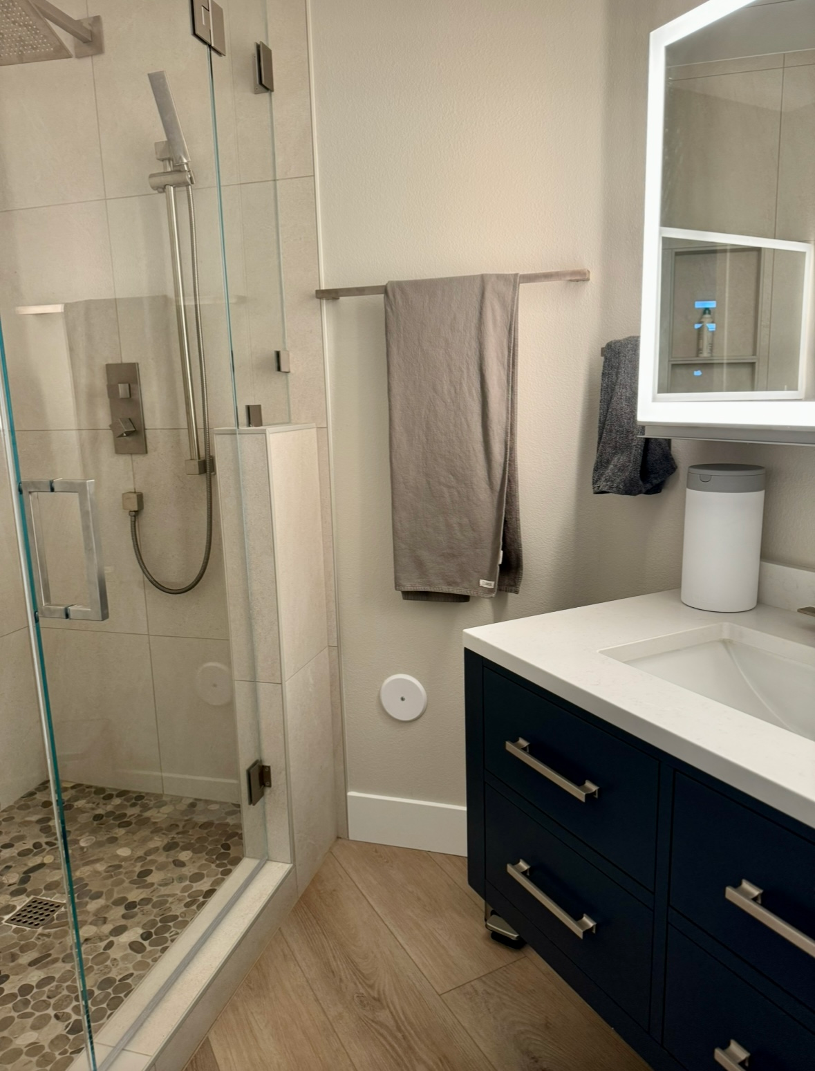 A bathroom with a sink , mirror and shower.