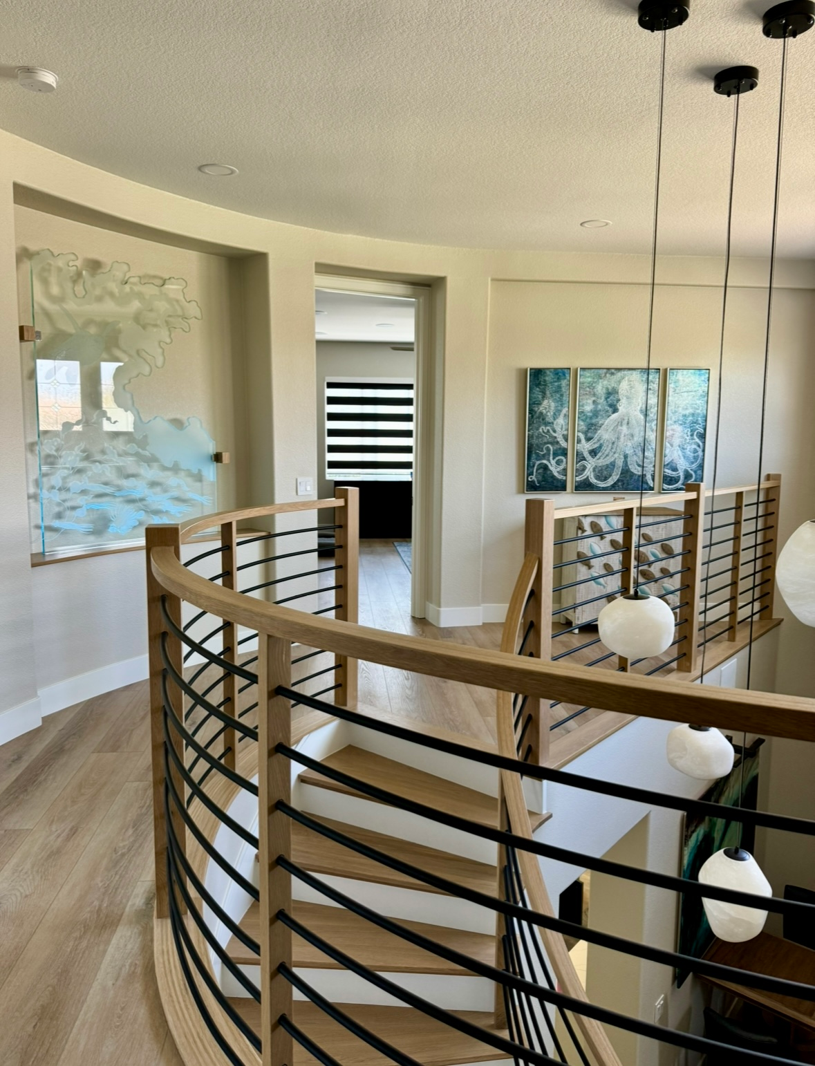 A curved staircase with a black railing in a house