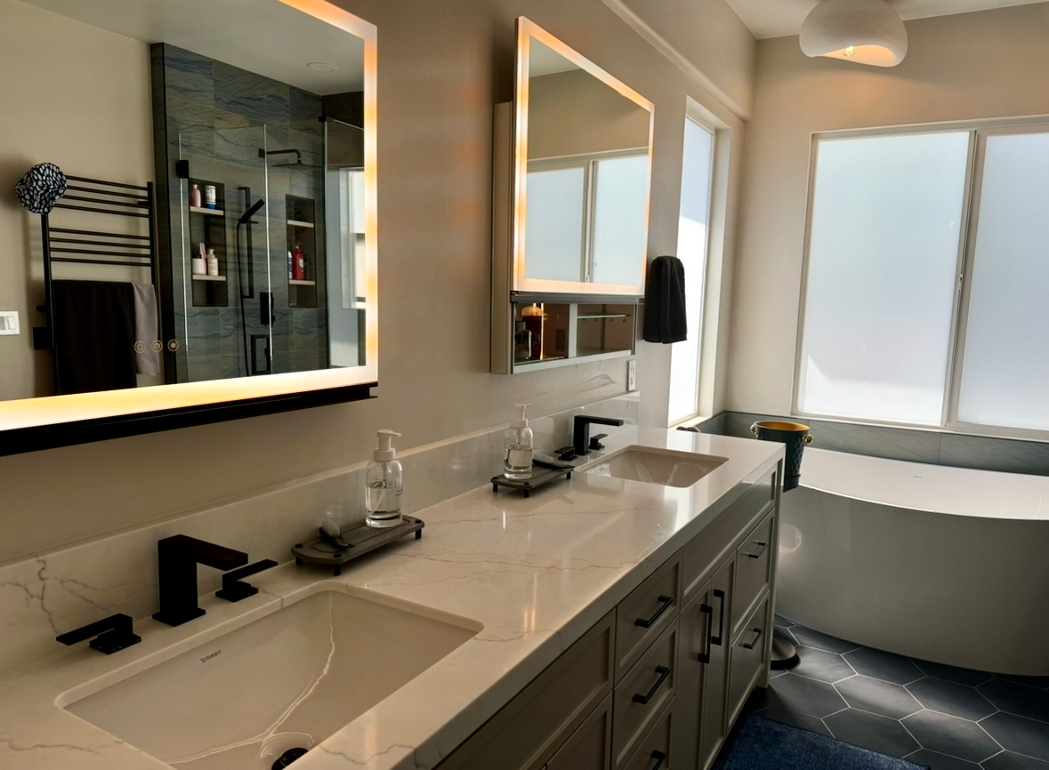 A bathroom with two sinks , two mirrors and a bathtub.