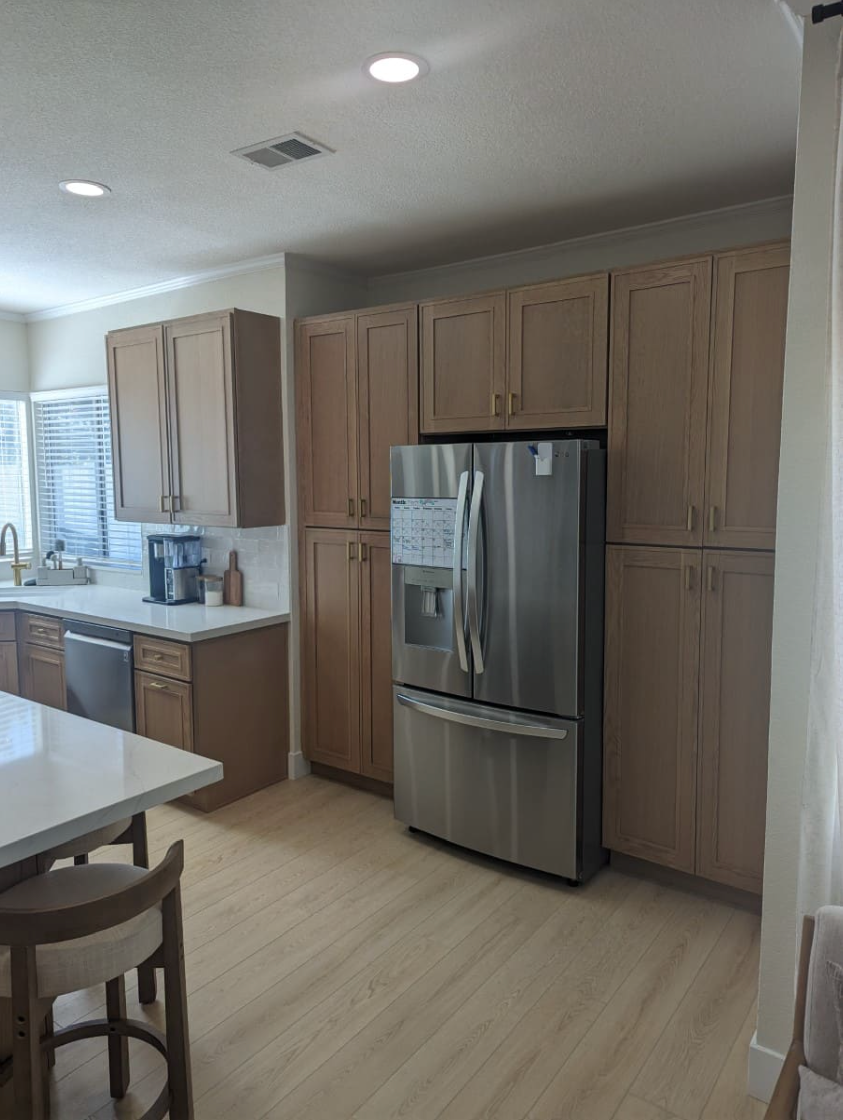 A kitchen with stainless steel appliances and wooden cabinets.