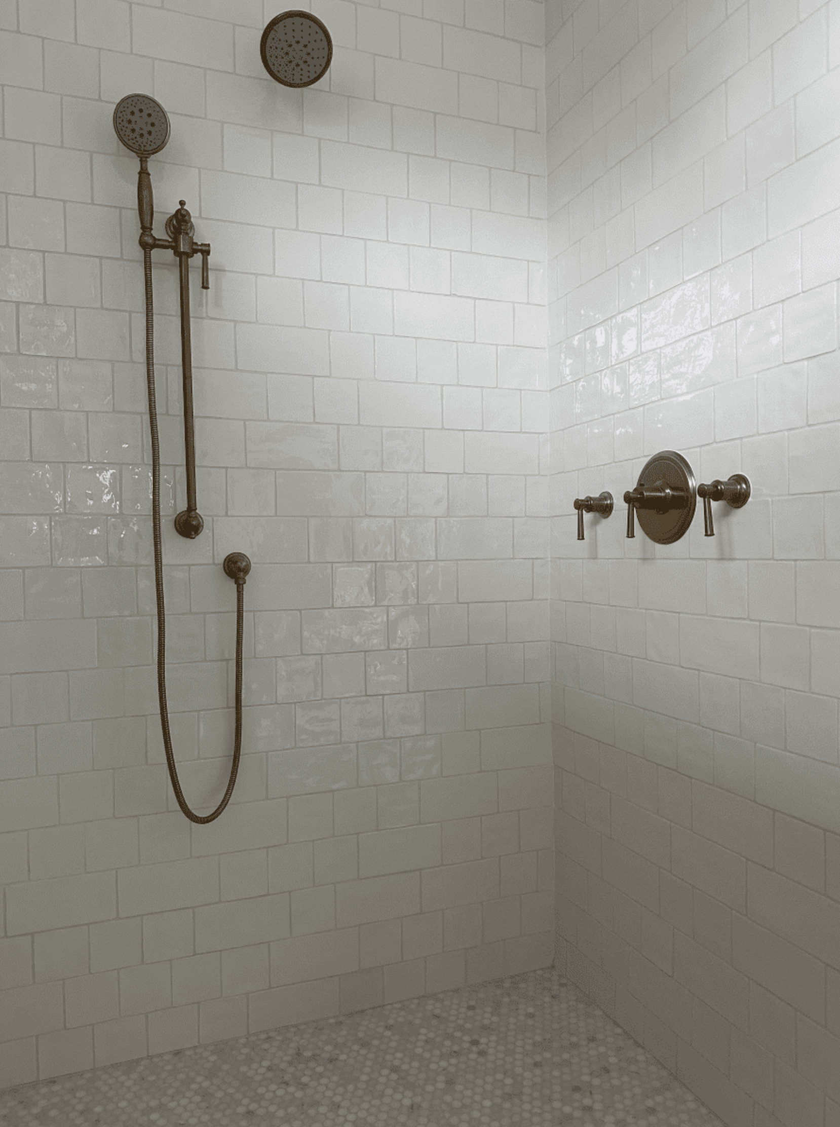 A shower with white tiles and a shower head.