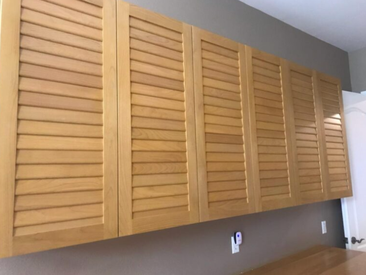 A bunch of wooden cabinets with shutters on them