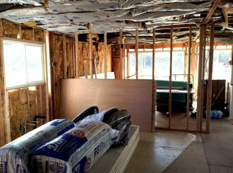 A room under construction with rolls of insulation on the floor