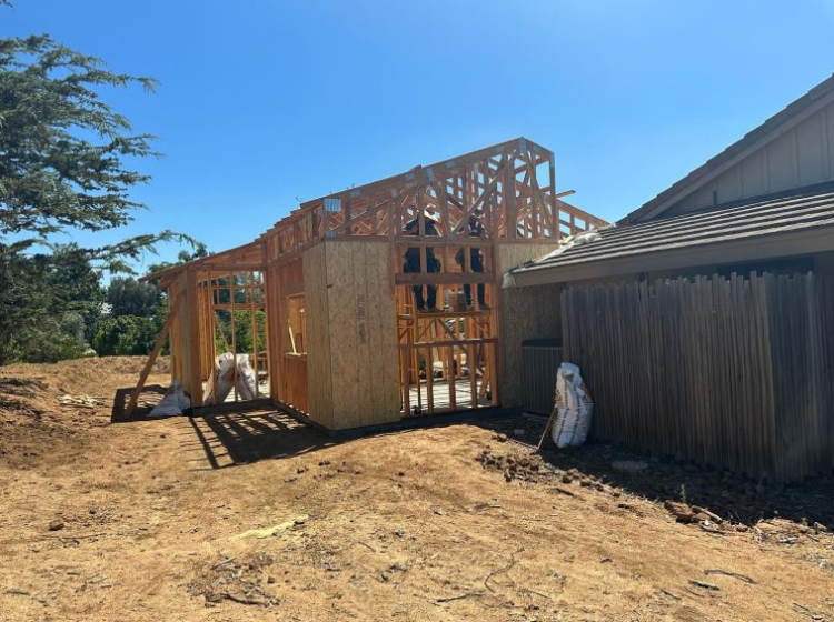 A house is being built in the backyard of a house.