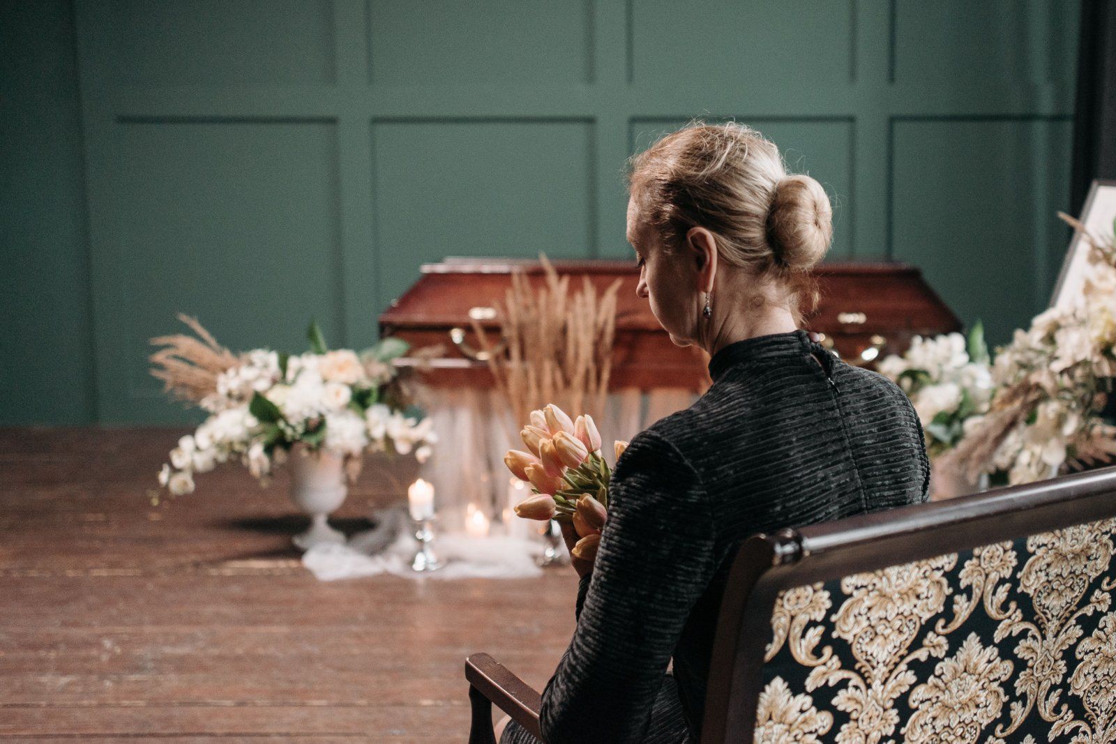 Woman holding flowers at a Cedarburg, WI funeral service, representing Eernisse Funeral Homes & Cremation Service.