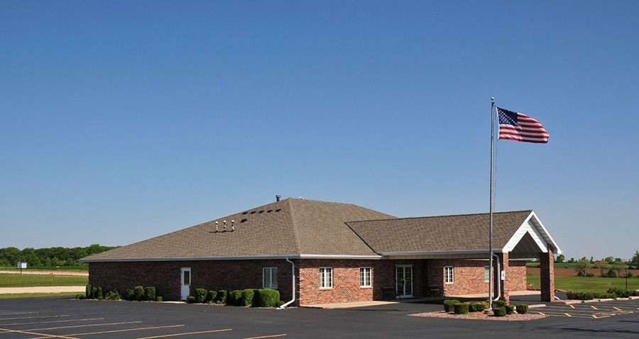 Front view of Eernisse Funeral Homes & Cremation Service facility with American flag and spacious parking area
