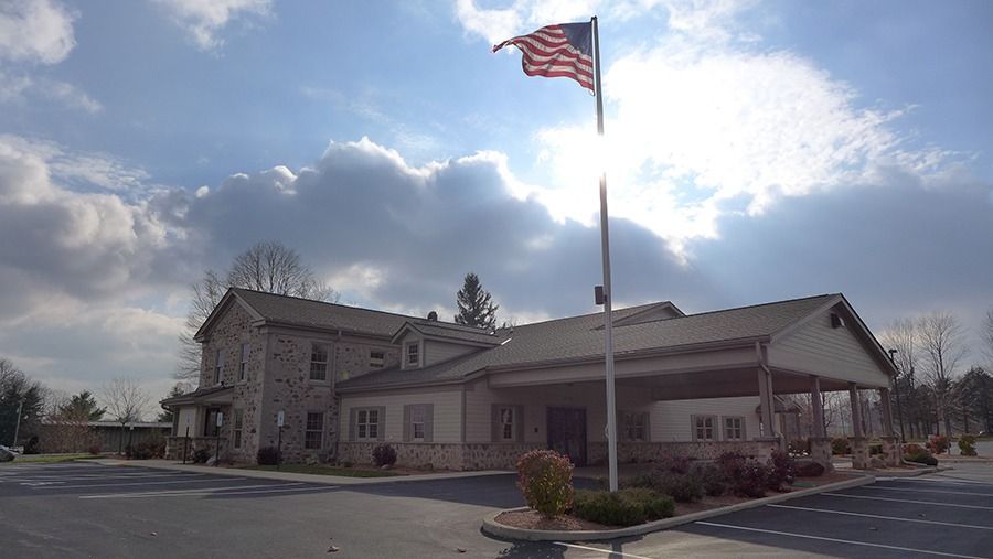 Eernisse Funeral Homes & Cremation Service exterior with stone façade and American flag in a serene setting
