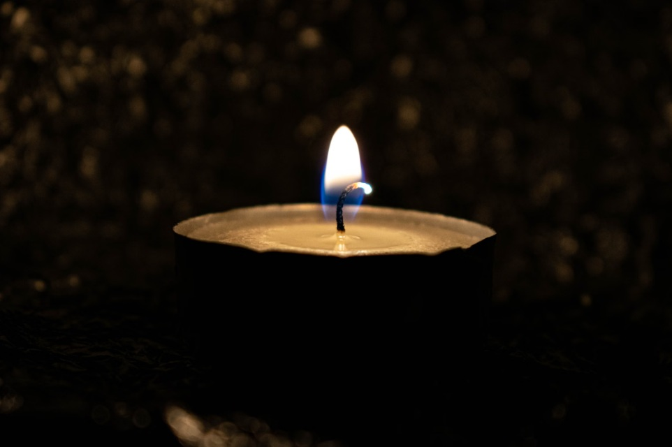 Single lit candle representing familiar traditions after cremation in Port Washington, WI.