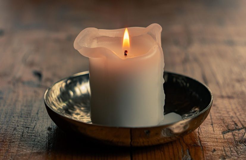 Lit memorial candle offering comfort during a farewell in Port Washington, WI.