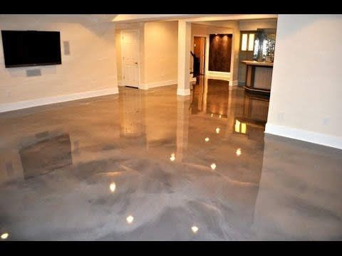 Empty living room with a glossy gray floor and a wall-mounted TV.