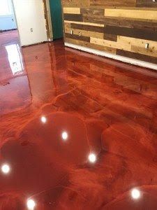 Glossy red epoxy floor with wood plank wall and doorway in a modern interior